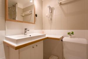 La salle de bains est pourvue d'un lavabo et de toilettes. dans l'établissement Résidence L'Atelier, à Ennezat