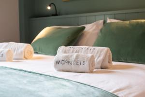 three towels sitting on top of a bed at Moontels Mercado de Ruzafa in Valencia