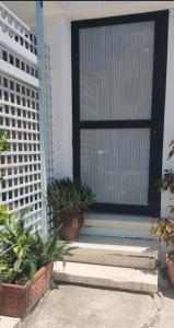 a door with potted plants in front of a house at Private Bedroom Paphos Central in Paphos City