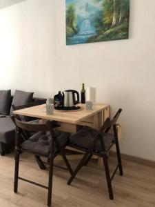 una mesa de madera y sillas con un hervidor de agua. en Superbe appartement meublé refait à neuf Tricastin, en Pierrelatte