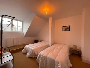 a bedroom with two beds in a attic at Grand appartement renové centre historique proche plages in Perros-Guirec