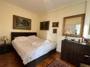 Dormitorio con cama con espejo y tocador en Vintage Delight Apartment Vracar Hram Sv Save, en Belgrado