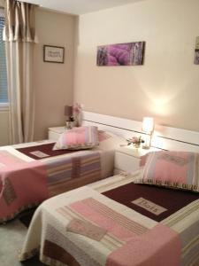 2 camas en una habitación pequeña con sábanas rosas en Les locs de Marie, en Sainte-Maxime