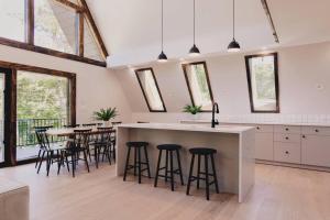 a kitchen with a island with bar stools at Emberwood Lodge - Luxury Cabin, Kid Friendly in Catskill