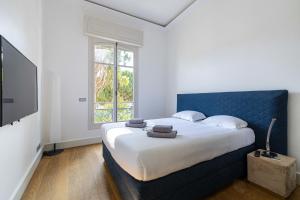 Schlafzimmer mit einem großen Bett mit blauem Kopfteil in der Unterkunft Superb 68m2 flat with 80m2 terrace - 2Ch4p in Cannes