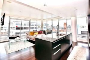 een keuken en een woonkamer met uitzicht op een gebouw bij Victoria's best location 2 bedroom luxe condo in Victoria