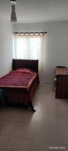 a bedroom with a red bed and a window at Private Bedroom Paphos Central in Paphos City