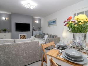 a living room with a couch and a table with flowers at The Bay Cottage in Morecambe