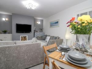 a living room with a couch and a table with flowers at The Bay Cottage - Morecambe Bay in Morecambe