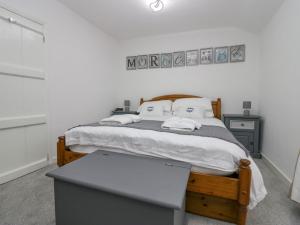a bedroom with a large bed with a wooden frame at The Bay Cottage - Morecambe Bay in Morecambe