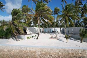 un edificio sulla spiaggia con palme di The Zanzibar Beach House-West a Pingwe