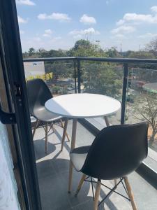 - Balcón con mesa blanca y 2 sillas en Vesta gardens, en Nairobi