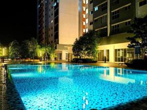 a large swimming pool with blue water at night at KLIA Homestay Apartment - 2 room in Sepang