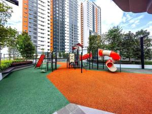 un parque infantil con un tobogán sobre una alfombra naranja en KLIA Homestay Apartment - 2 room, en Sepang