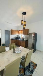 a kitchen with a table with chairs and a refrigerator at KLIA Homestay Apartment - 2 room in Sepang