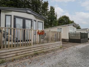 a house with a fence and a flower pot on it at Burlees Nest in Cockermouth