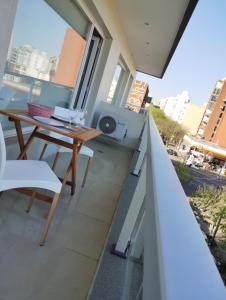 Elle comprend un balcon avec une table et des chaises en bois. dans l'établissement Calmo Dooneo Appart La Plata - Departamentos con COCHERA, à La Plata