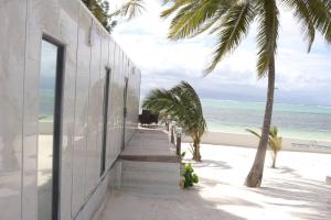 un edificio en la playa con palmeras y el océano en The Zanzibar Beach House-West, en Pingwe