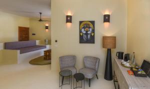 Alma Boutique Hotel في جامبياني: غرفة معيشة مع كرسيين وأريكة