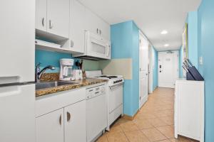 a kitchen with white appliances and blue walls at Avista Resort 1503 in Myrtle Beach