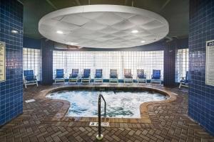 a hot tub in a room with blue chairs at Avista Resort 1503 in Myrtle Beach