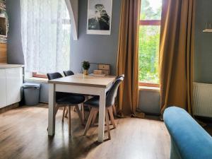 a dining room table with chairs and a window at Winna Góra in Oława