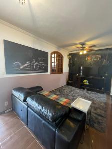 a living room with a leather couch and a table at Casa Lazer&Tranquilidade @lazer.tranquilidade in Brumadinho