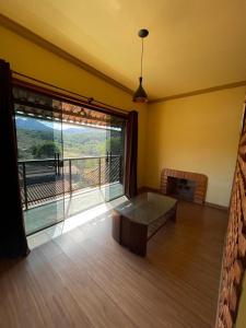 a living room with a table and a large window at Casa Lazer&Tranquilidade @lazer.tranquilidade in Brumadinho