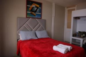 - une chambre avec un lit rouge et des serviettes dans l'établissement La Belle Vue, à Lima