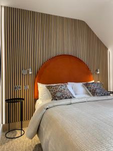 a bedroom with a large bed with a wooden headboard at The Boutique Hotel in Faringdon
