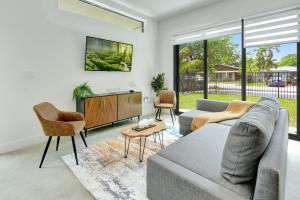 sala de estar con sofá, sillas y TV en Fresco 1, Modern Design, Brand New Construction and Furniture, en Miami