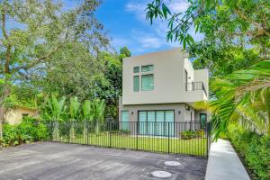 a white house with a black fence and trees at Fresco 1, Modern Design, Brand New Construction and Furniture in Miami
