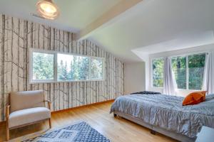 een slaapkamer met een bed, een stoel en ramen bij Contemporary Portland Retreat with Forest Views in Portland