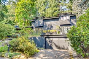 una casa nera con garage e recinzione di Contemporary Portland Retreat with Forest Views a Portland