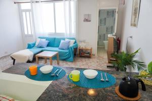 a living room with two tables and a blue couch at Marina Blue, Las Caletillas in Candelaria