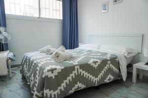 a bedroom with a bed with a brown and white blanket at Marina Blue, Las Caletillas in Candelaria +25 photos