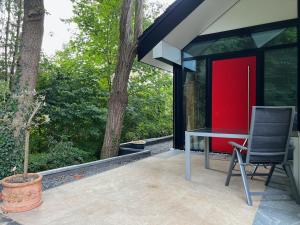 una mesa y una silla en un patio con árboles en Neues Exclusives 2 Schlafzimmer Apartment Hamburg en Hamburgo