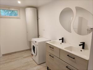 a bathroom with a washing machine and a sink at Maison avec jacuzzi proche plages in Avrillé +6 photos