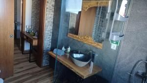 uma casa de banho com um lavatório e um espelho em Stone House em Lagoa