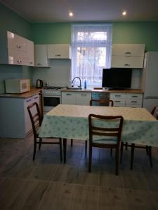 een keuken met een tafel en stoelen en een wastafel bij Kwatery pracownicze in Środa Wielkopolska