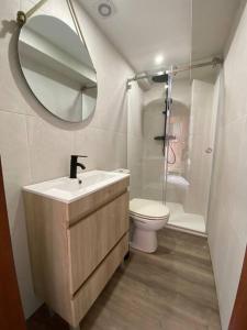 un bagno con lavandino, WC e specchio di Casa Antunes a Évora