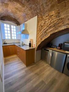 cocina grande con pared de piedra y suelo de madera en Casa Antunes en Évora