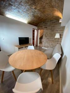 Casa Antunes في ايفورا: غرفة طعام مع طاولة خشبية وكراسي بيضاء