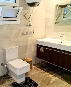 a bathroom with a white toilet and a sink at Two Bedroom Luxury Apartment in New Cairo in Cairo