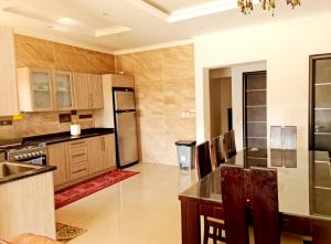 a large kitchen with a refrigerator and a table at Two Bedroom Luxury Apartment in New Cairo in Cairo