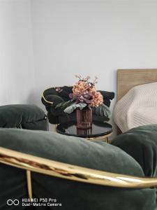 una mesa con un jarrón de flores sobre una silla en Robik Studio Militari Residence en Roşu
