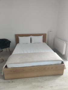 1 dormitorio con 1 cama grande con marco de madera en Robik Studio Militari Residence en Roşu