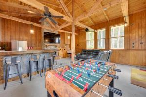 a large living room with a table with a football game on it at Milledgeville Home with Private Dock and Dock House! in Milledgeville