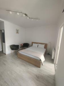 een witte slaapkamer met een bed en een tafel bij Robik Studio Militari Residence in Roşu