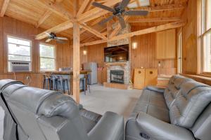 a living room with leather furniture and a ceiling fan at Milledgeville Home with Private Dock and Dock House! in Milledgeville